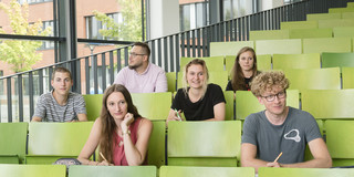 A group of students are sitting in a lecture hall.